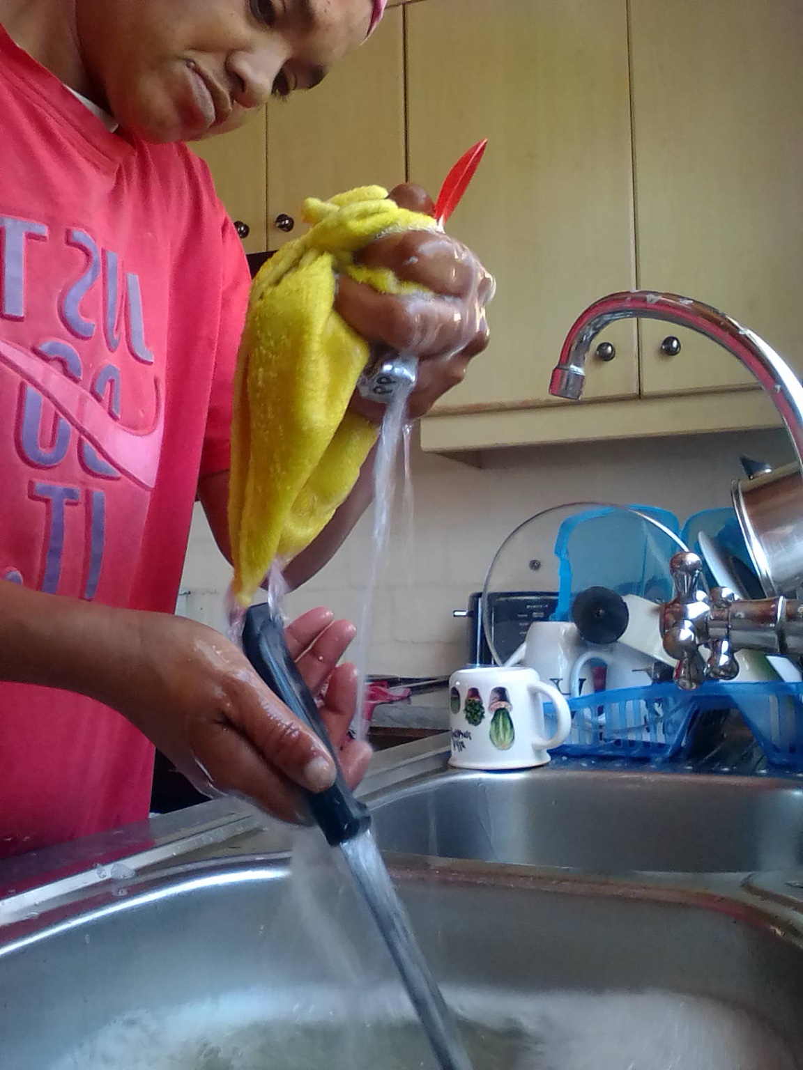 Rinsing utensils as part of a deep clean in a modern kitchen